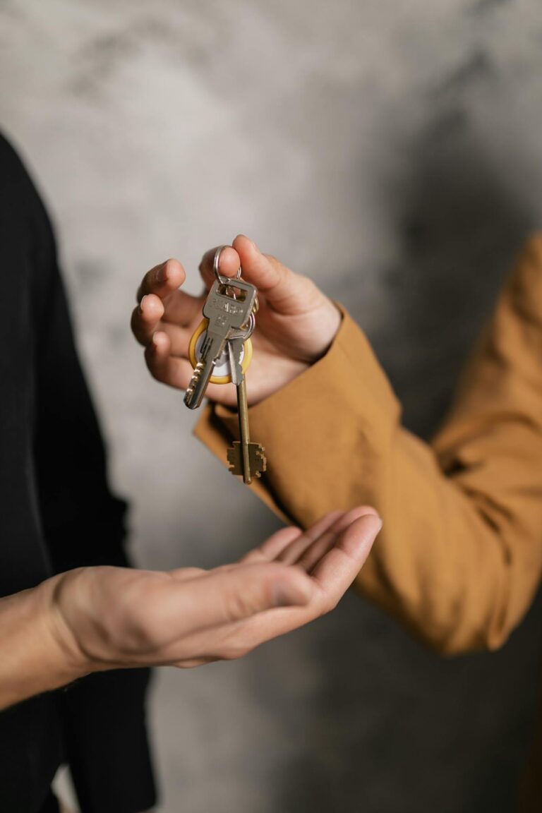 Two adults exchanging house keys, symbolic of property transfer in Auckland rental market.
