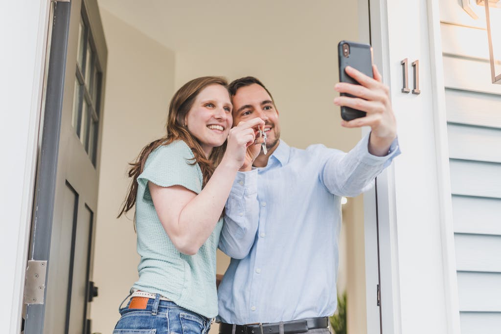 Happy couple takes a selfie while celebrating keys to their new rental home.