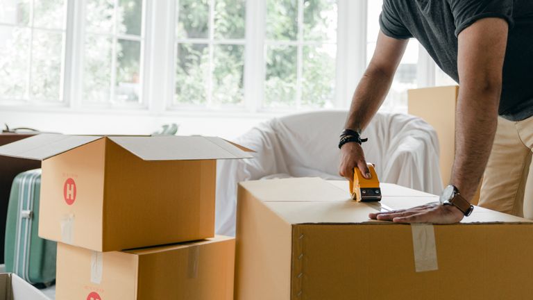 Man packing boxes is part of how to get your bond back when you move out of your rental.